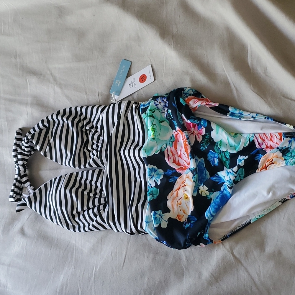1 piece halter top swimming suit. Black and stripes and floral print. Size M NWT